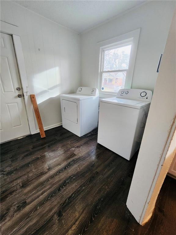 clothes washing area featuring dark wood-type flooring and washing machine and dryer