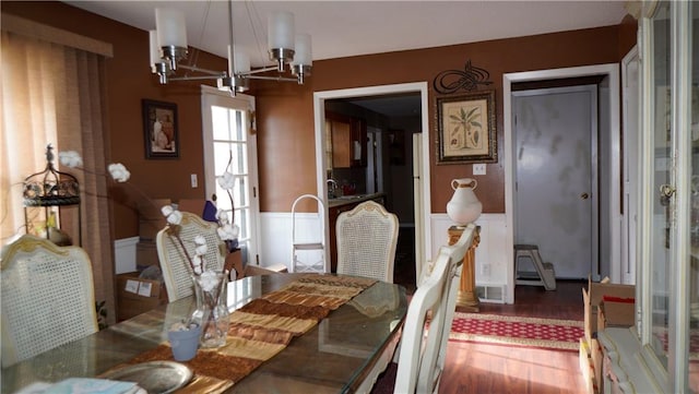 dining area with hardwood / wood-style floors, a notable chandelier, and sink