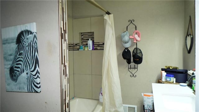 bathroom with shower / bath combination with curtain and vanity