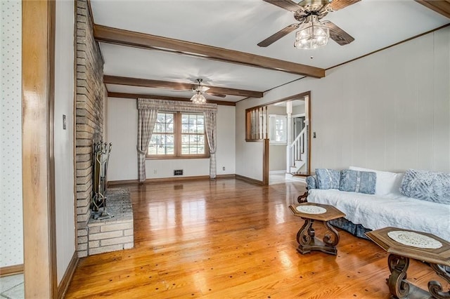 living room with beamed ceiling, hardwood / wood-style flooring, and ceiling fan