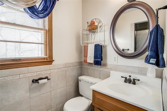 bathroom with vanity, tile walls, and toilet