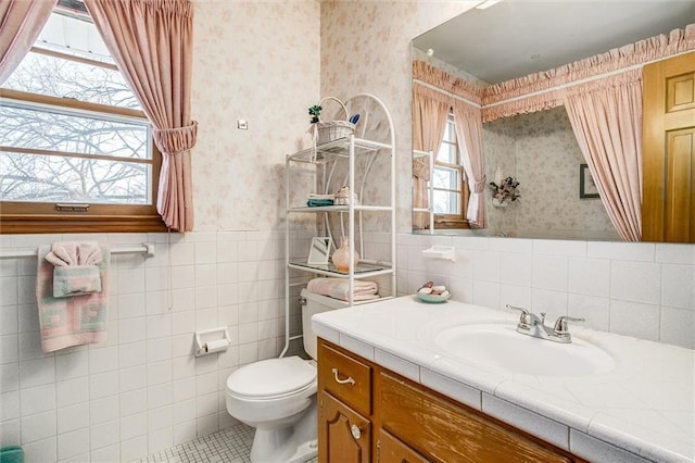 bathroom with tile patterned flooring, vanity, tile walls, and toilet