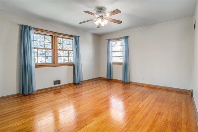 unfurnished room with ceiling fan, a wealth of natural light, and light hardwood / wood-style flooring