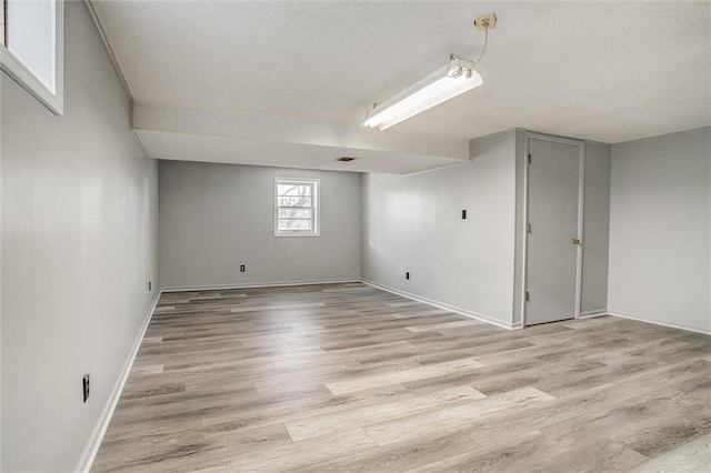 basement with light hardwood / wood-style flooring