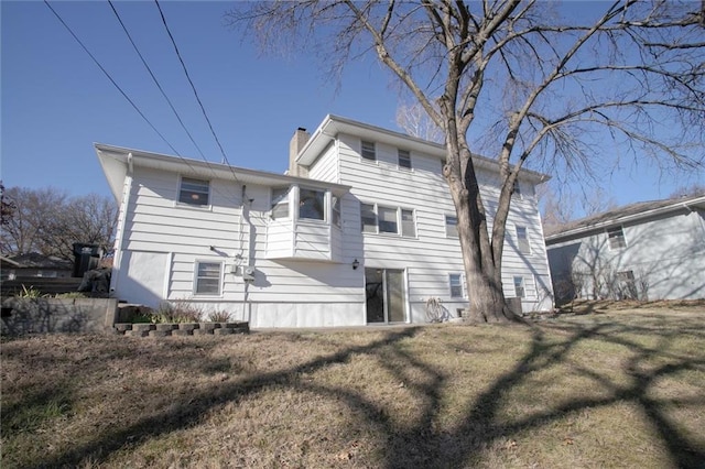 rear view of property featuring a lawn