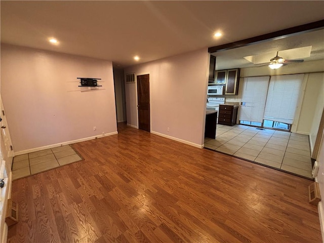 unfurnished living room with light wood-type flooring and ceiling fan