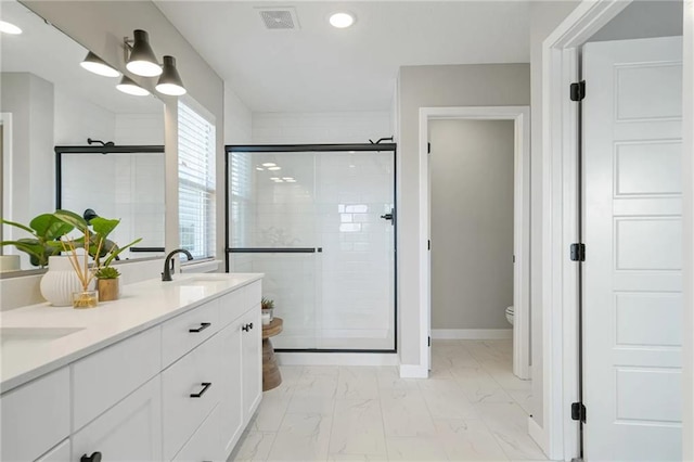 bathroom with walk in shower, vanity, and toilet