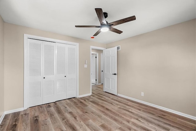 unfurnished bedroom featuring ceiling fan, a closet, and light hardwood / wood-style flooring