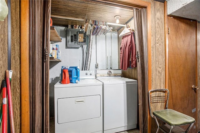 clothes washing area with separate washer and dryer and electric panel