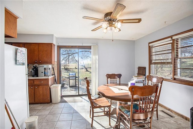 dining room with plenty of natural light, ceiling fan, and light tile patterned floors