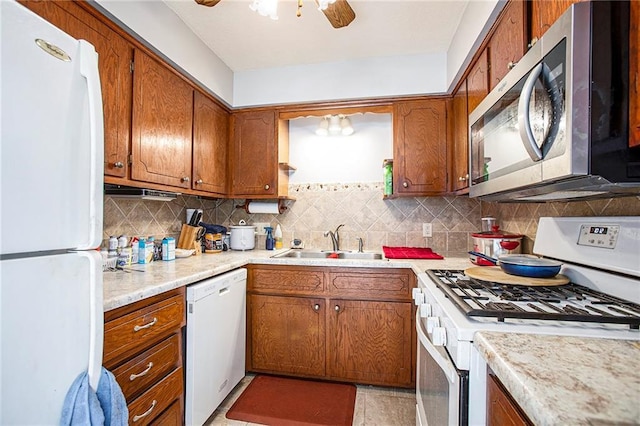 kitchen with sink, white appliances, ceiling fan, and backsplash