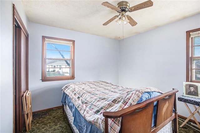 bedroom with ceiling fan, a closet, dark carpet, and a textured ceiling