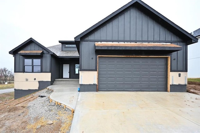 modern farmhouse with board and batten siding, concrete driveway, and a shingled roof