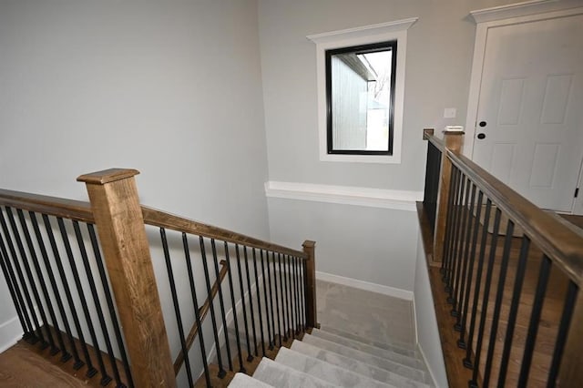 staircase with baseboards and carpet floors