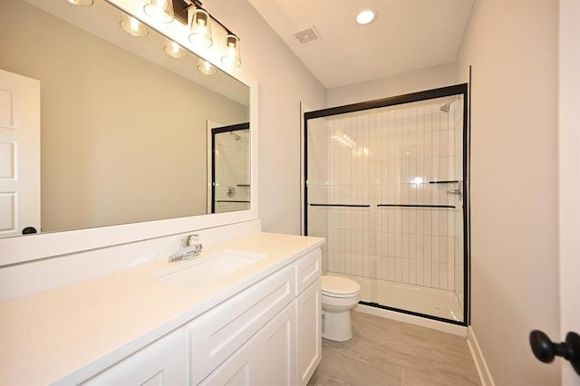 full bath with visible vents, toilet, vanity, and a tile shower