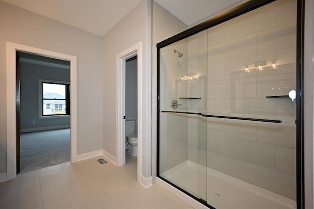 full bath with tile patterned floors, a shower stall, toilet, and baseboards