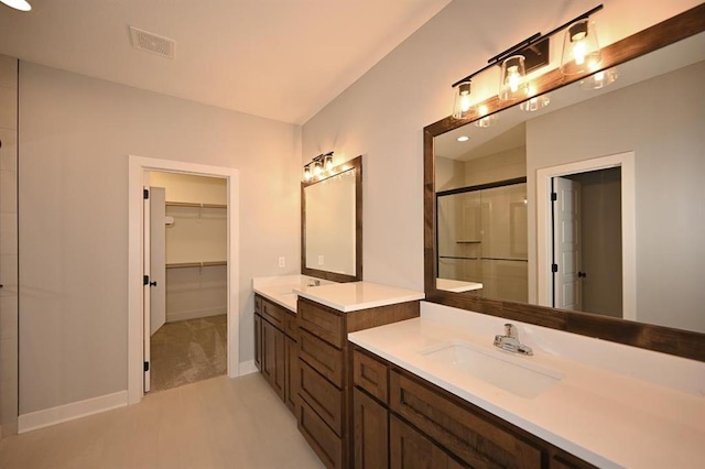 bathroom with visible vents, a stall shower, two vanities, and a sink