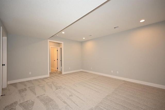 empty room with light colored carpet, recessed lighting, and baseboards