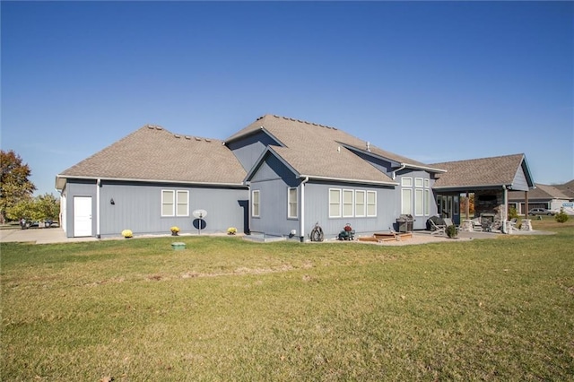 rear view of property featuring a patio area and a yard