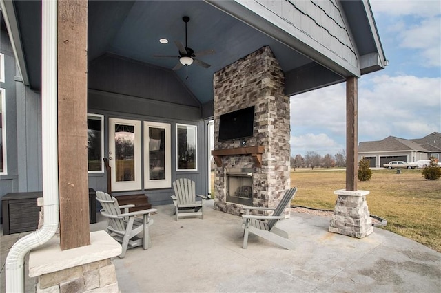 view of patio with an outdoor stone fireplace and ceiling fan