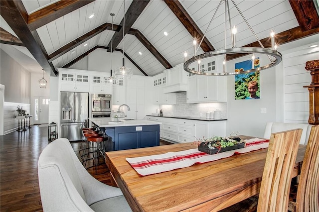 dining room featuring beam ceiling, dark hardwood / wood-style floors, high vaulted ceiling, and sink