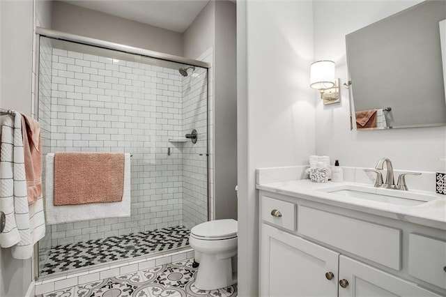 bathroom featuring toilet, vanity, tile patterned floors, and walk in shower