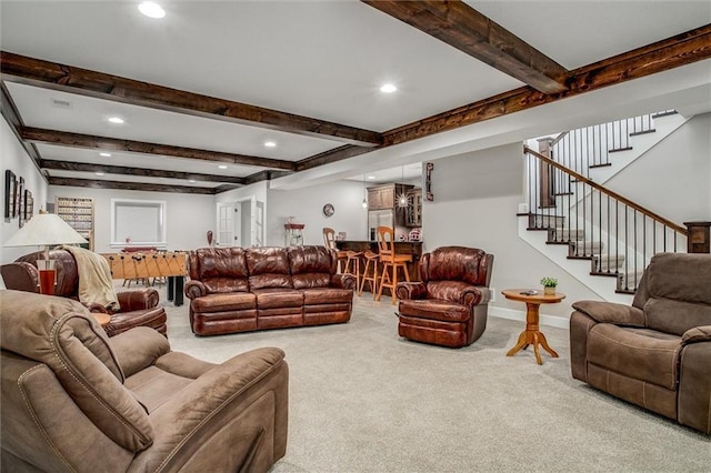 carpeted living room featuring beam ceiling