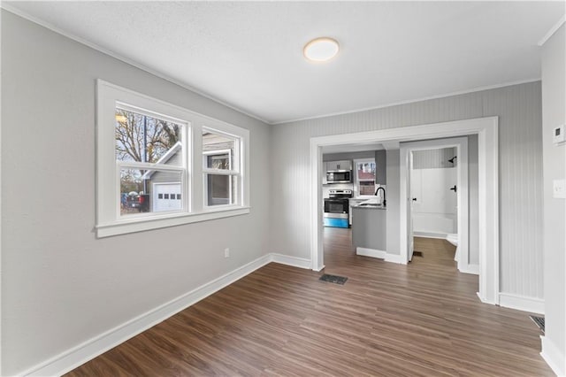 interior space featuring crown molding, dark wood-type flooring, and sink