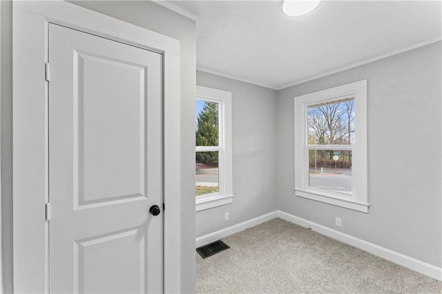 unfurnished room with carpet flooring, plenty of natural light, and ornamental molding