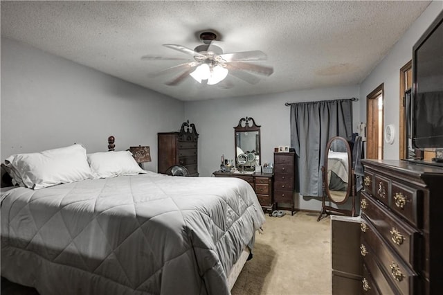 carpeted bedroom featuring ceiling fan and a textured ceiling