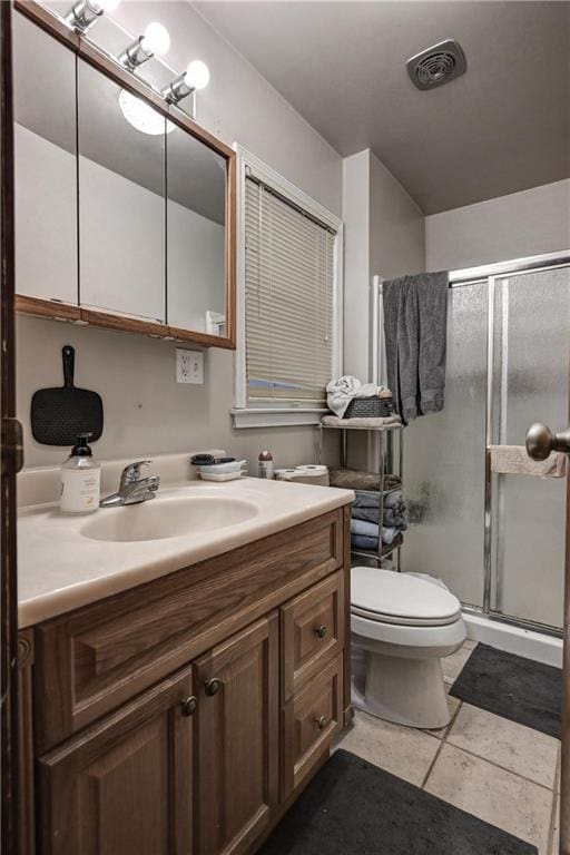 bathroom with tile patterned floors, vanity, toilet, and an enclosed shower