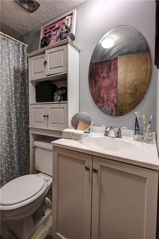 bathroom featuring vanity, a textured ceiling, and toilet