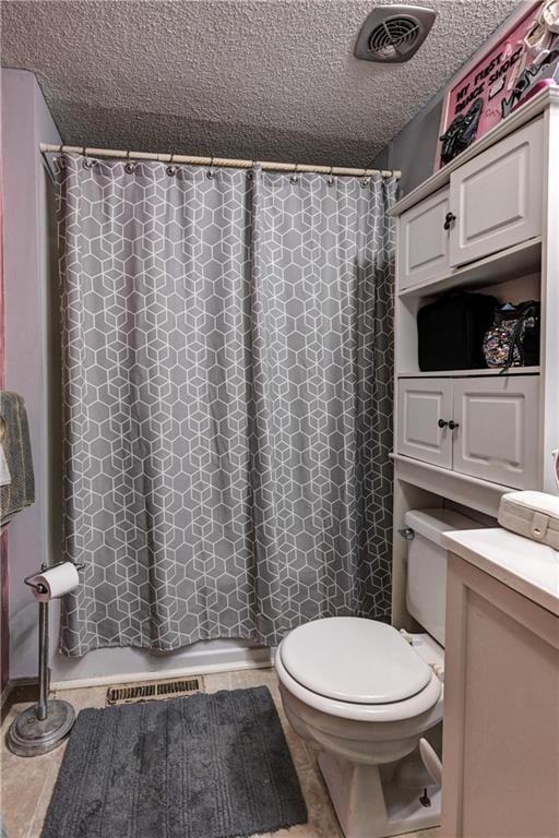 bathroom featuring tile patterned flooring, a shower with shower curtain, a textured ceiling, and toilet