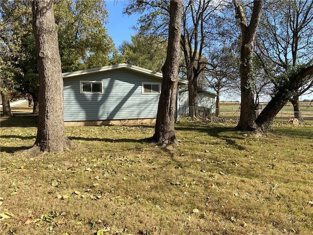 view of side of home featuring an outbuilding and a yard