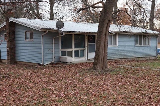 rear view of property featuring a sunroom