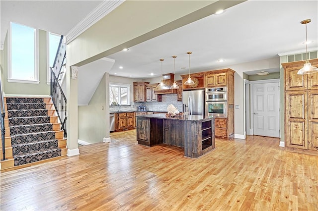 kitchen with premium range hood, decorative light fixtures, light wood-type flooring, a kitchen island, and stainless steel appliances