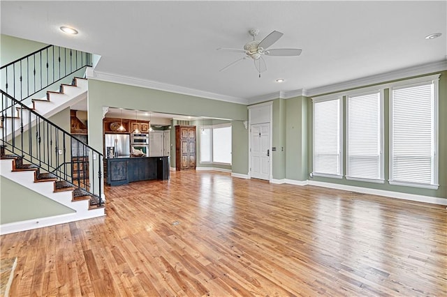 unfurnished living room featuring crown molding, light wood-type flooring, and ceiling fan