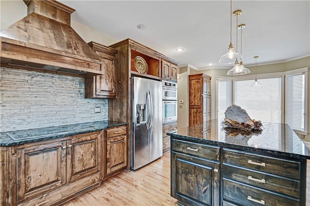 kitchen featuring pendant lighting, stainless steel appliances, custom range hood, and dark stone counters