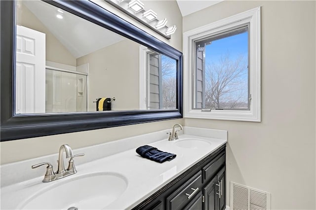 bathroom with vaulted ceiling, vanity, and a shower with shower door