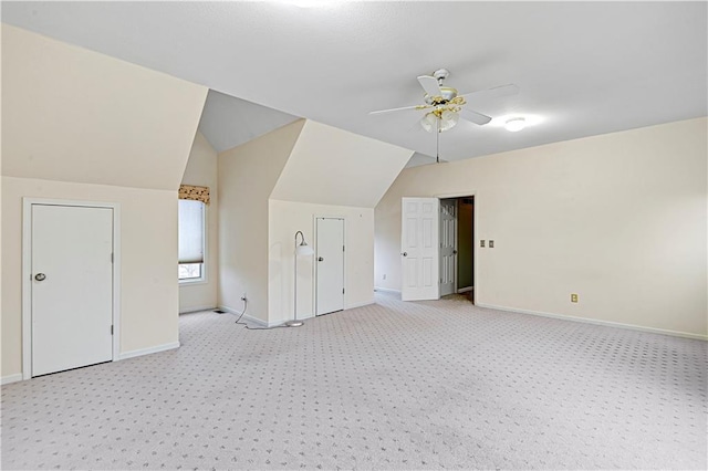 additional living space with ceiling fan, lofted ceiling, and light colored carpet