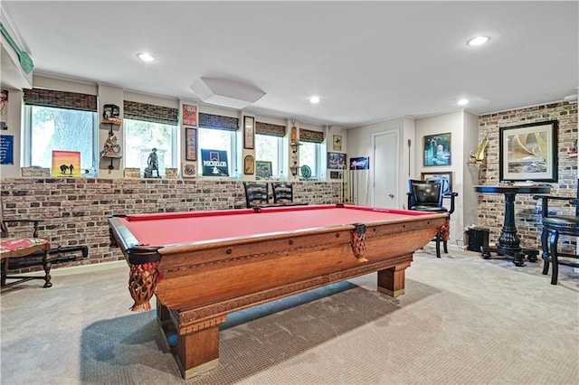 game room featuring light colored carpet, brick wall, and a wealth of natural light