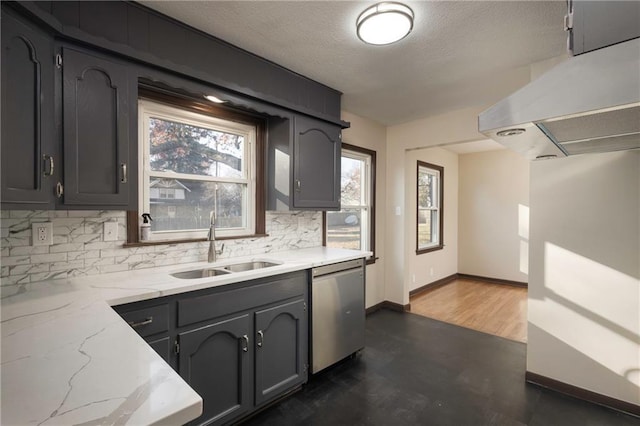 kitchen with stainless steel dishwasher, decorative backsplash, sink, and a textured ceiling