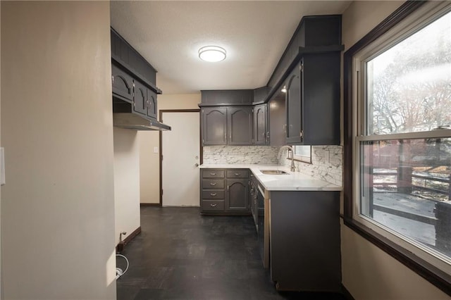 kitchen with decorative backsplash, sink, and a textured ceiling