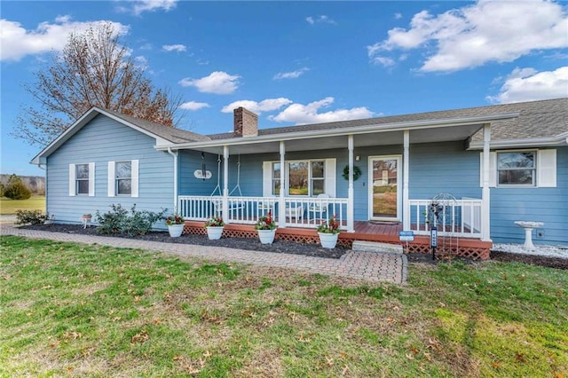 ranch-style home featuring covered porch and a front yard