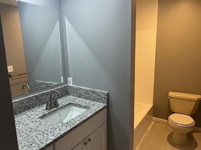 bathroom with tile patterned flooring, vanity, toilet, and a washtub