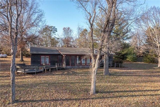 view of front of house featuring a front lawn and a deck