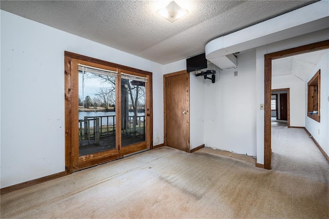 spare room featuring a textured ceiling and light carpet