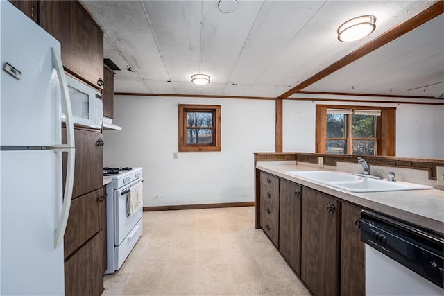 kitchen featuring dark brown cabinets, sink, and white appliances