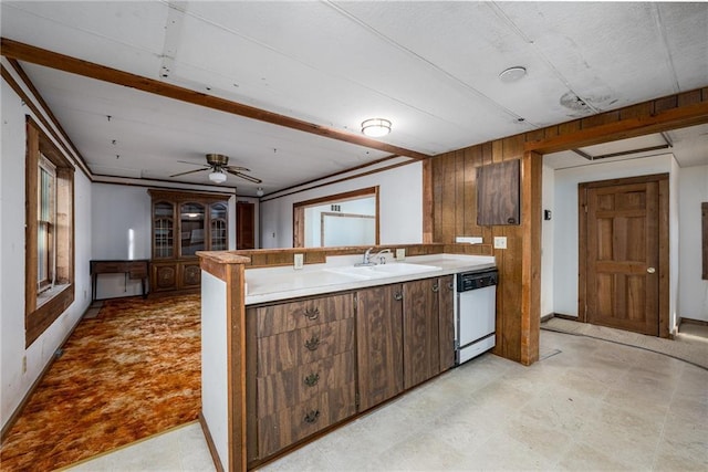 kitchen with dishwasher, sink, kitchen peninsula, wood walls, and ceiling fan