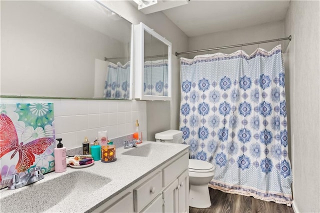 bathroom with toilet, wood-type flooring, tile walls, vanity, and decorative backsplash